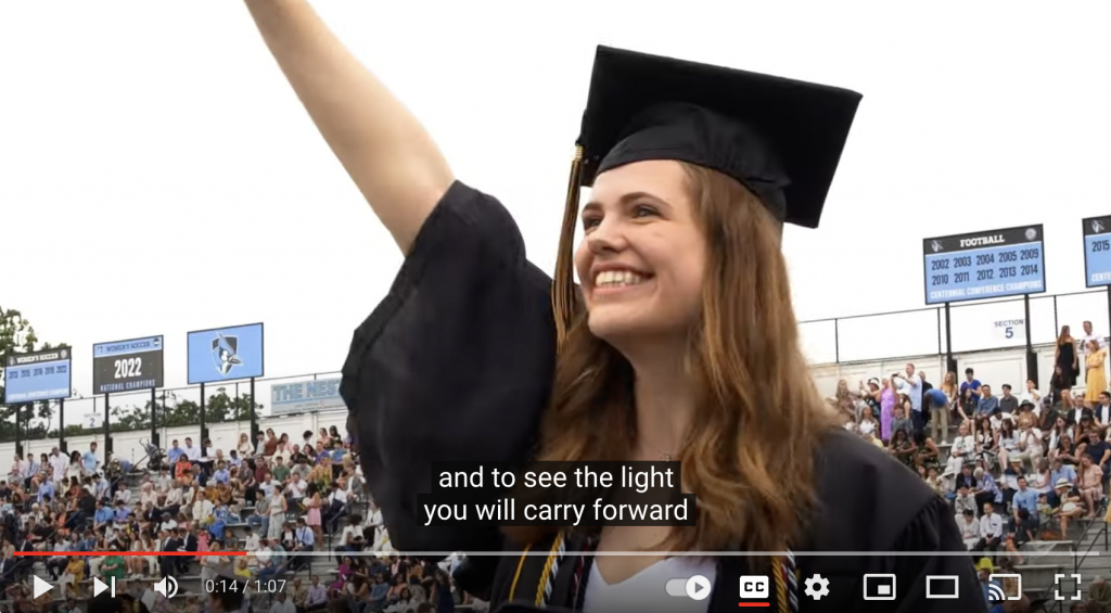 Screen capture of student waving during the Commencement recap video